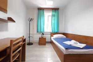 a bedroom with a bed and a window with blue curtains at Rooms Studentsko Naselje Ivan Goran Kovačić in Rijeka