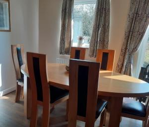 a dining room table with chairs and a wooden table at Woodpecker Cottage in Carnguwch