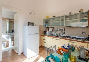 a kitchen with a white refrigerator and a table at Casa Alessia in Porto Santo Stefano +15 photos