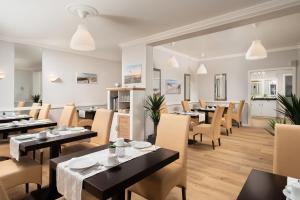 a restaurant with tables and chairs in a room at Hotel Haus am Park in Borkum