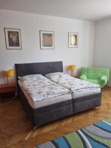 sypialnia z dużym łóżkiem i zieloną kanapą w obiekcie Apartmans Les w Zlinie