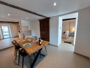 a dining room with a wooden table and chairs at La Ferme des Sottais in Burg-Reuland