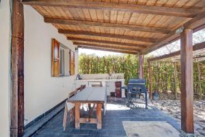 patio con mesa de madera y cocina en Rosadimaggio Camelia, en Arcola