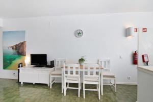 - une salle à manger avec une table, un ordinateur et des chaises dans l'établissement Ocean View Apartment Hakuna Matata, à Albufeira