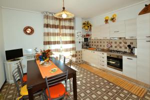 a kitchen with a table and chairs in a room at Casa Patty in Sirmione