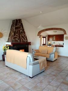 sala de estar con 2 sofás y chimenea en VILLA LUPINO, en Orosei
