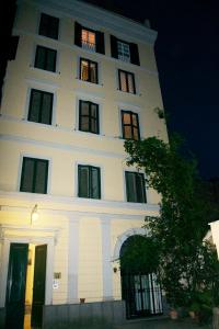 wysoki biały budynek z oknami w nocy w obiekcie House Colosseo w Rzymie
