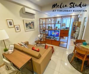 TimurBay Seafront Residences by Melia Studio في كُوانتان: غرفة معيشة مع أريكة وطاولة
