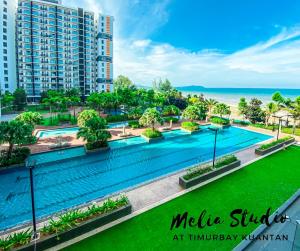 una imagen de una piscina en un complejo con el océano en TimurBay Seafront Residences by Melia Studio, en Kuantan