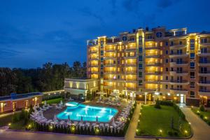 a hotel with a swimming pool in front of a building at Landmark Creek Hotel & Wellness Plovdiv in Plovdiv
