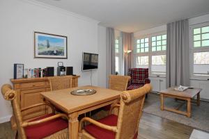 a living room with a wooden table and chairs at La Mer Wohnung 1 in Kühlungsborn