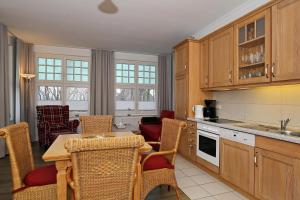 une cuisine avec une table et des chaises ainsi qu'une salle à manger dans l'établissement La Mer Wohnung 1, à Kühlungsborn