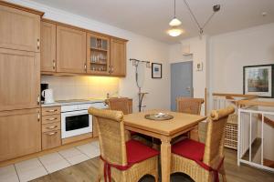 a kitchen with a table and chairs in a room at La Mer Wohnung 1 in Kühlungsborn +16 photos