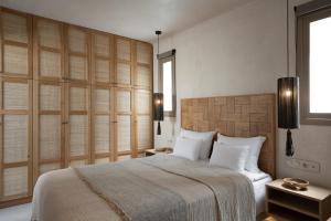 a bedroom with a large bed with white pillows at Areos Luxury Suites in Vóthon +51 photos