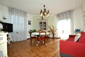 a living room with a table and a red couch at Casa Patty in Sirmione