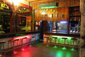 a bar with red and green neon stools at Hotel Daylu in Iquitos