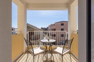 a balcony with a table and chairs on a balcony at PORTO SERENO apartments in Šibenik