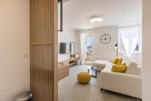 un soggiorno con divano bianco e TV di PORTO SERENO apartments a Šibenik