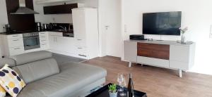 a living room with a couch and a flat screen tv at Das AMBIENTE I - Komfortables Wohnerlebnis mit Moselromantik - Herzlich Willkommen - in Zell an der Mosel