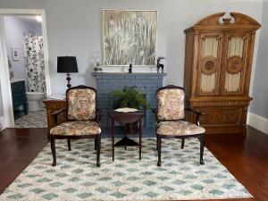 ein Wohnzimmer mit 2 Stühlen und einem Tisch in der Unterkunft Seabank House Bed and Breakfast Hummingbird in Pictou