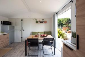 a kitchen and dining room with a table and chairs at Camping Le Rey in Louvie Juzon