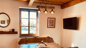 sala de estar con TV y ventana en Penzion, Restaurace Jaro Věšín Brdy, en Rožmitál pod Třemšínem