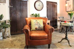 una silla de cuero marrón con una almohada de cebra. en Bramley Cottage at Stepps House, en Broadway
