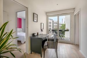 an office with a desk in a room with a balcony at En plein coeur de ville, bel appartement pour cinq personnes in Nantes