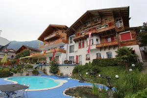 a hotel with a swimming pool in front of a building at Holiday Apartment Beauregard in Brienz