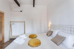 a white bed with two pillows on top of it at Maison d'Orange - La Pinede in Saint-Tropez