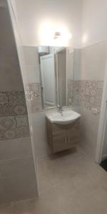 W łazience znajduje się umywalka, lustro i prysznic. w obiekcie Borgo Santa Lucia Apartment w mieście Neapol +32 zdjęcia