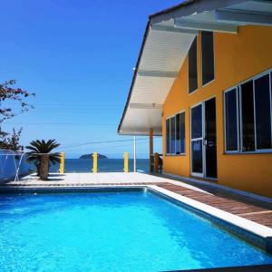 una piscina frente a una casa en Mansão Ouro Verde Vlc Frente para o Mar com Piscina, en Piçarras