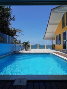 uma piscina em frente a uma casa em Mansão Ouro Verde Vlc Frente para o Mar com Piscina em Piçarras