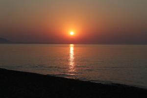puesta de sol en la playa con puesta de sol en Ktima Tzaneti - Coastal Farmhouse, en Lachania