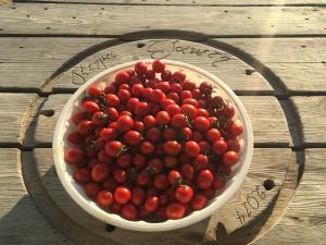 a bowl of tomatoes on a wooden table at Ktima Tzaneti - Coastal Farmhouse in Lachania