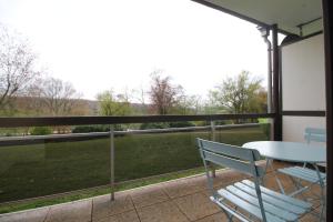 a balcony with a table and chairs and a view of a field at Oscappart in Eupen