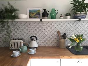 a kitchen with a counter with cups and a toaster at Bay Cottage & Bay Stables in Torpoint +30 photos