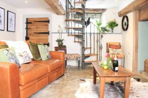 ein Wohnzimmer mit einem orangenen Sofa und einem Holztisch in der Unterkunft Bramley Cottage at Stepps House in Broadway + 16 Fotos