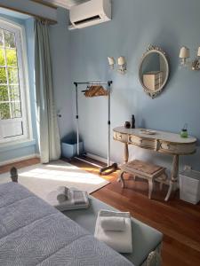 a bedroom with a bed and a table and a mirror at Casa Delft in Furnas
