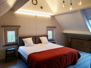 een slaapkamer met een groot bed en een rode deken bij Vakantieverblijf Volmolen B&B in Maaseik