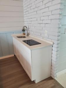 a kitchen with a sink and a white brick wall at Hollywood Gardens Inn & Suites in Hollywood +12 photos