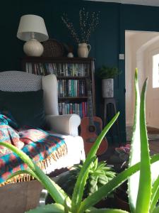 a living room with a couch and a book shelf at Bay Cottage & Bay Stables in Torpoint