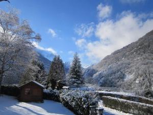 una cabaña en la nieve con montañas en el fondo en Villa 180 m² proche 3 vallées et station thermale en Champoulet