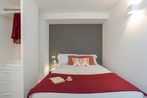 a small bedroom with a bed with a red blanket at Suite Brunate - by MyHomeInComo in Como