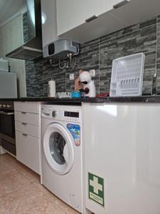 uma cozinha com uma máquina de lavar roupa em "Apartamentos do Farol" com vista para o mar em Santa Cruz das Flores