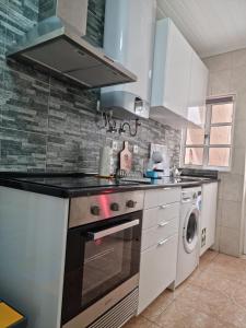 a kitchen with a stove and a washer and dryer at "Apartamentos do Farol" com vista para o mar in Santa Cruz das Flores