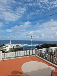 d'un balcon avec une table et une vue sur l'océan. dans l'établissement "Apartamentos do Farol" com vista para o mar, à Santa Cruz das Flores