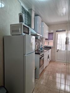 a kitchen with a white refrigerator and a stove at "Apartamentos do Farol" com vista para o mar in Santa Cruz das Flores +38 photos