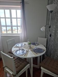 a dining room table with a white table and chairs at "Apartamentos do Farol" com vista para o mar in Santa Cruz das Flores +35 photos