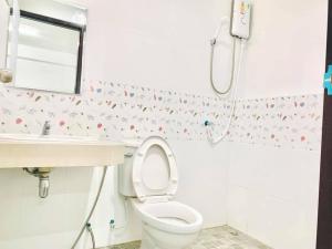 a bathroom with a toilet and a sink at MY HOME Hotel - Phutthamonthon 4 Road, near Mahidol University Salaya in Ban Krathum Lom